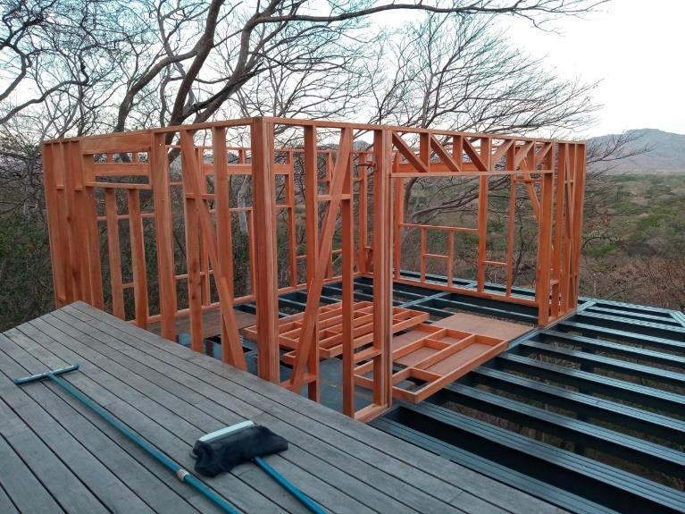Estructura de madera de la cabaña elevada sobre las vigas metálicas